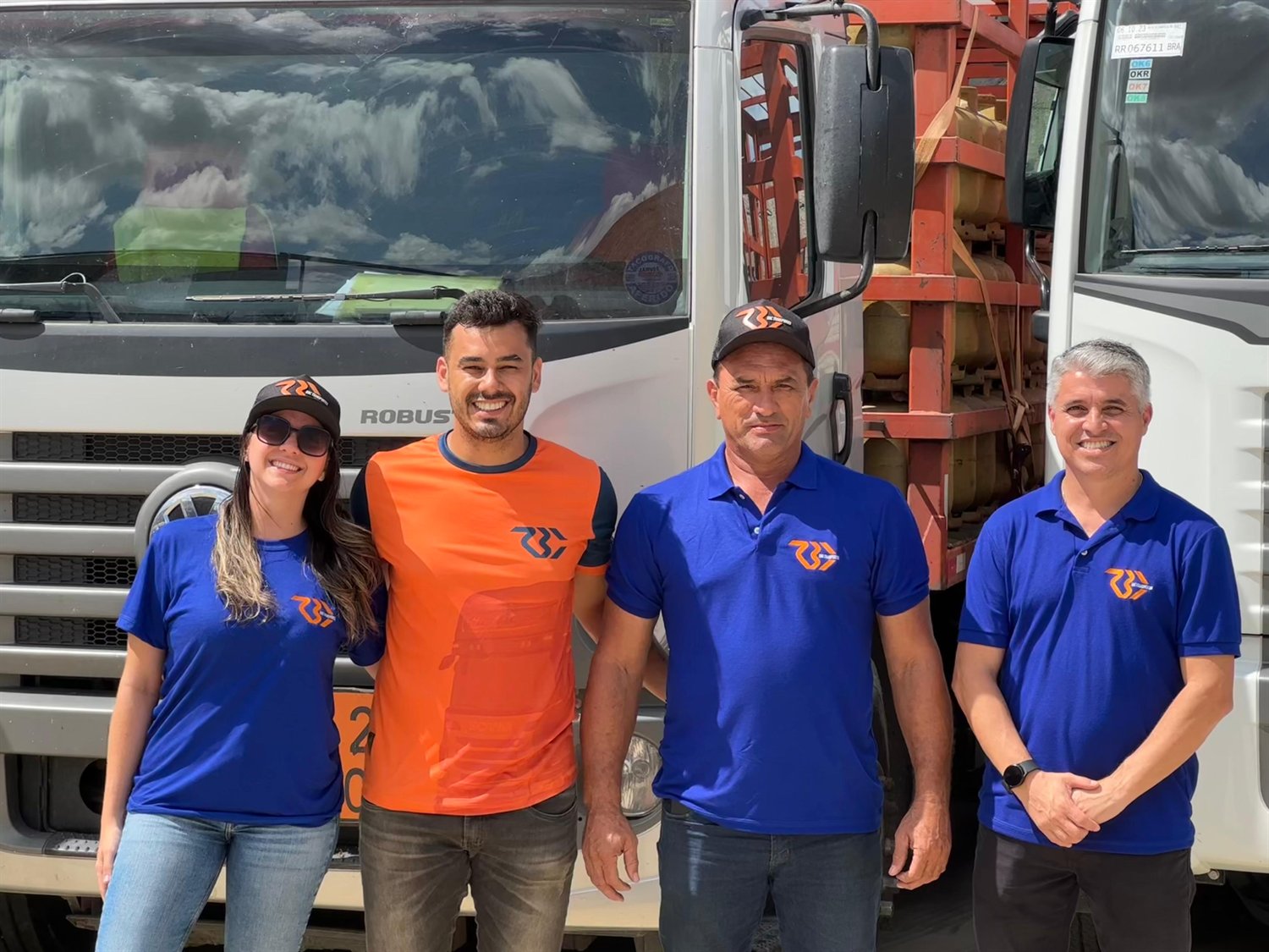 Equipe uniformizada da RBC Transportes em frente a um caminhão